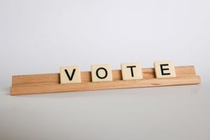 letters spell vote on a board