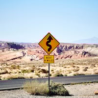Winding Road sign for next four miles in a desert