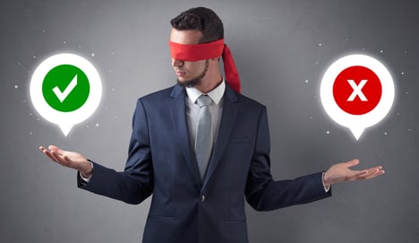 Blindfolded businessman with checked and x mark above his hand
