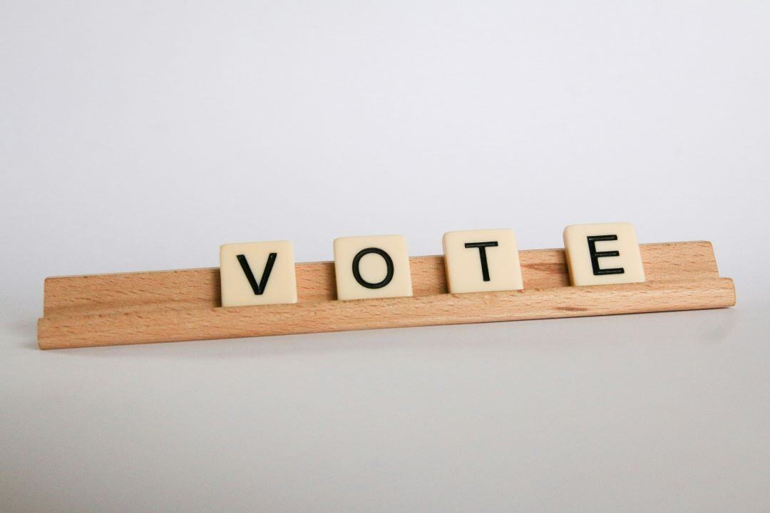 letters spell vote on a board