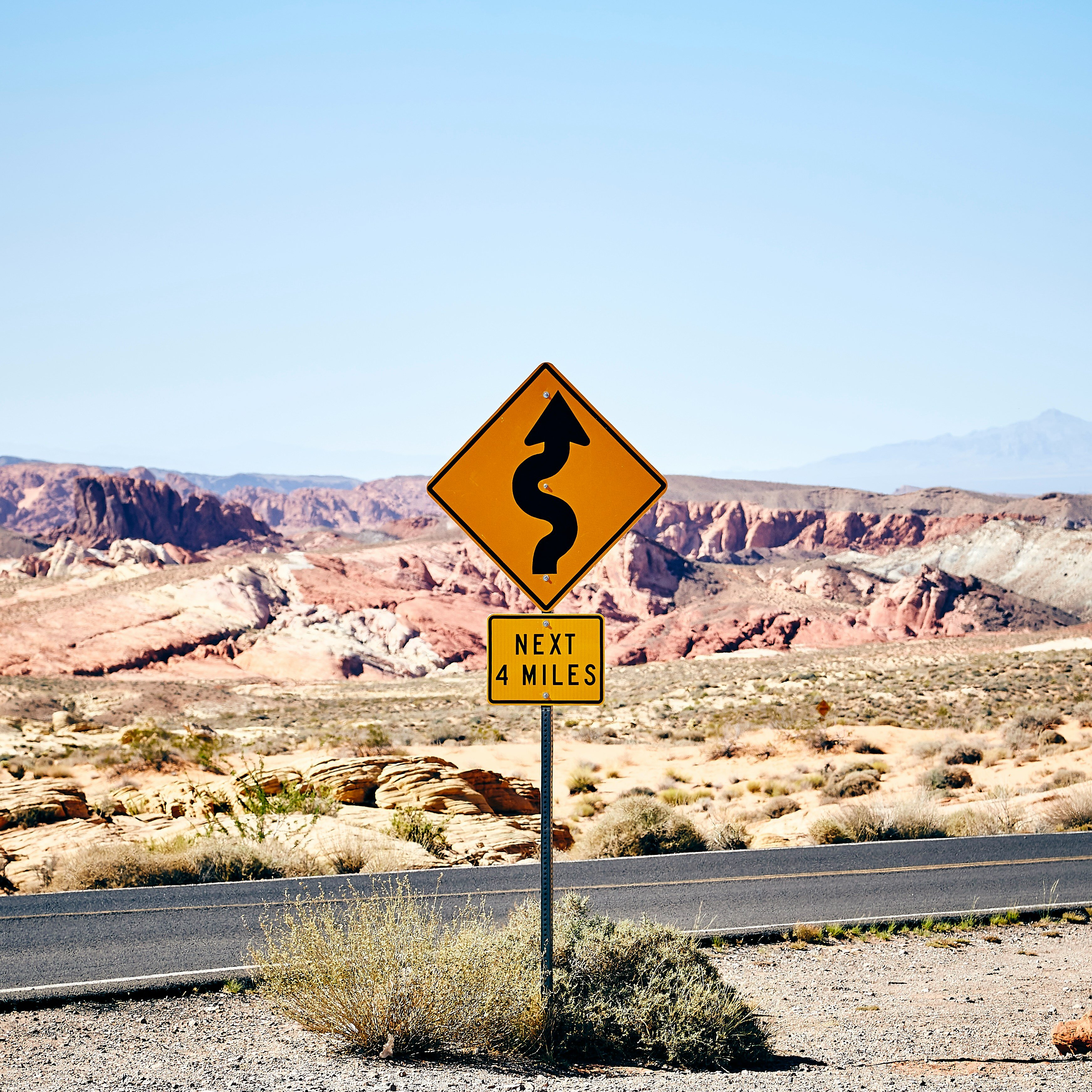 Winding Road sign for next four miles in a desert