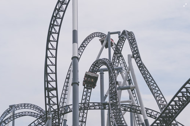 Roller coaster track against a white sky