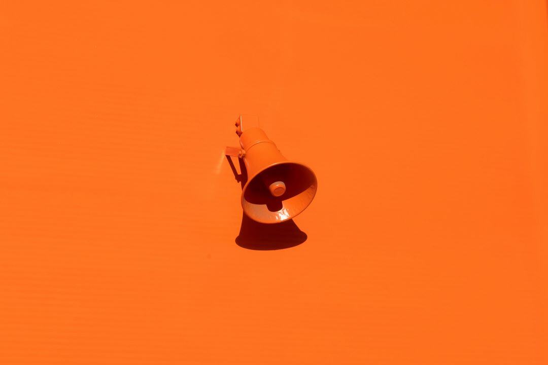 Orange speaker mounted on orange wall